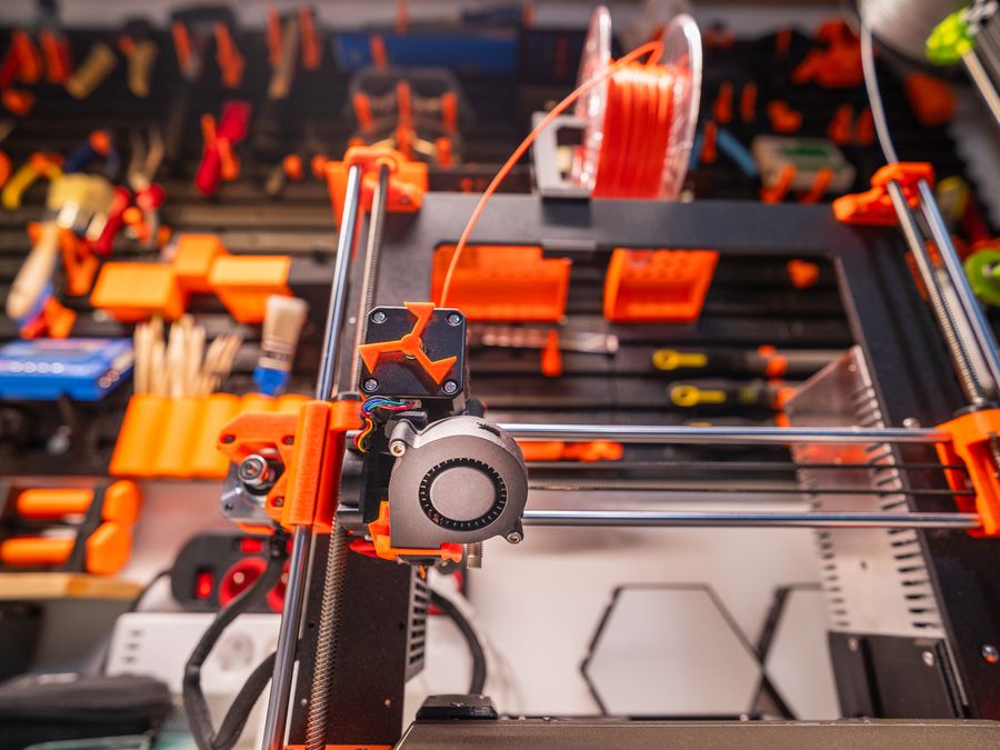 Mesin cetak 3D beroperasi di depan dinding perkakas workshop